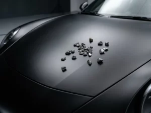 Autorijkap met matte zwarte vinylwrap en grind op het oppervlak, beschermende folie zonder krassen of beschadigingen.